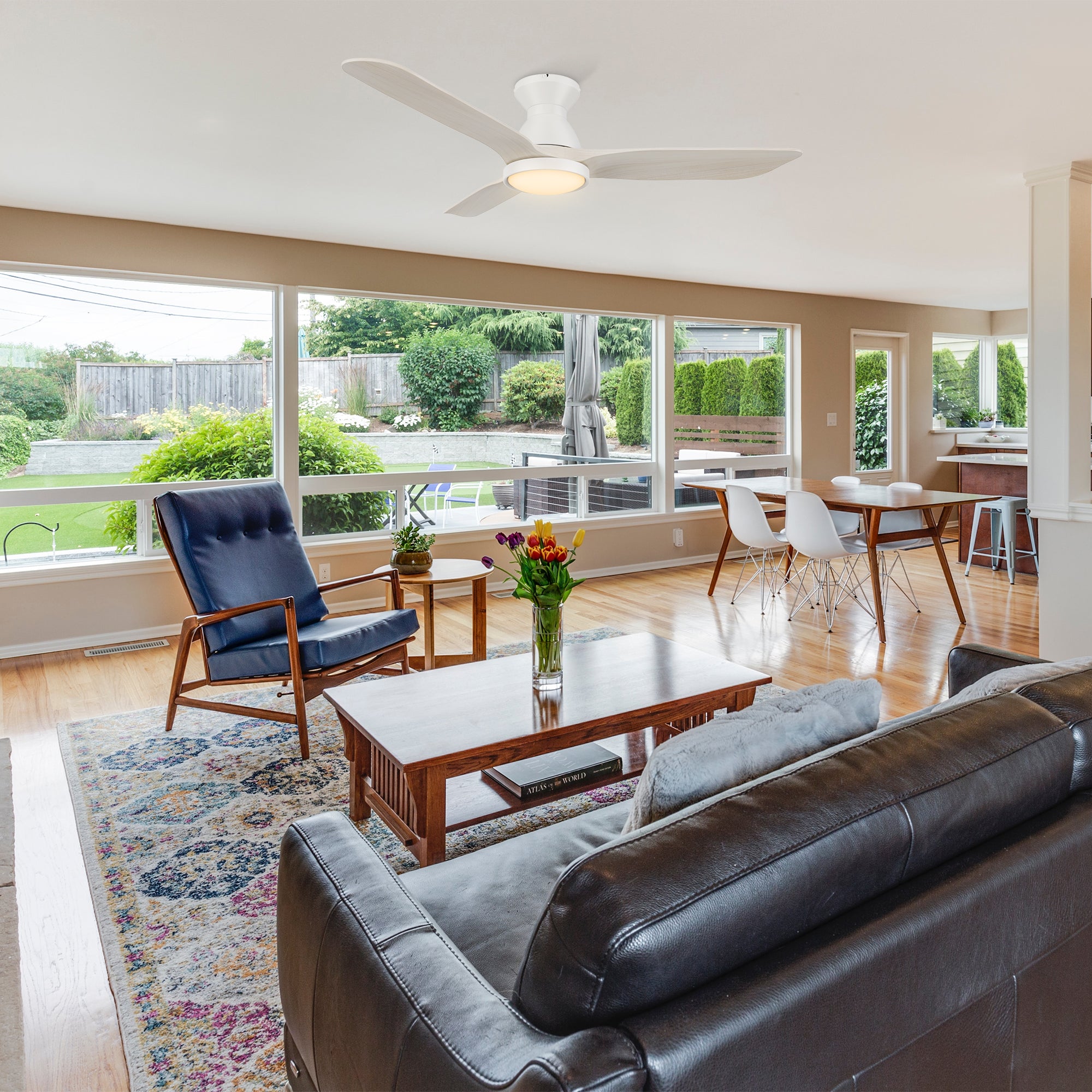 Lainey 52-inch low profile remote ceiling fan with light, installed in a spacious living room with large windows. 