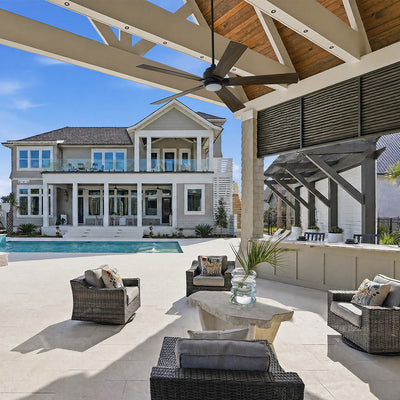 Outdoor patio featuring a 5-blade Aspen 60-inch smart ceiling fan in dark wood gra with an integrated LED light, complementing the bright, white-painted ceiling and providing a modern, functional cooling solution for the porch. #color_wood