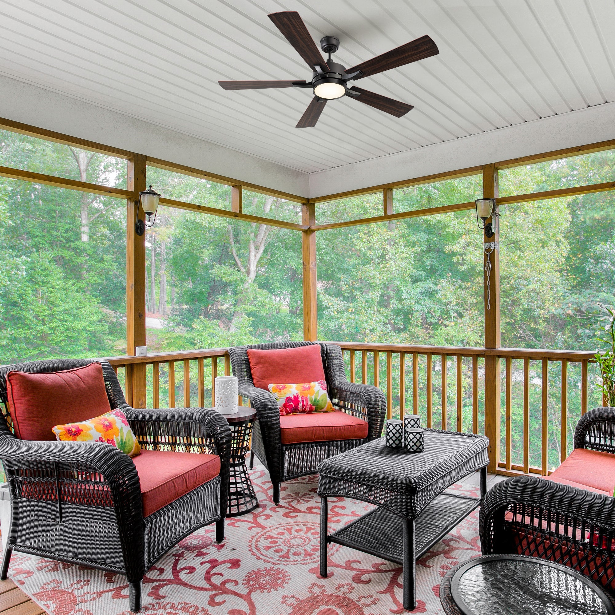Smafan Apex 56-inch outdoor smart ceiling fan with LED light installed in a screened-in patio with wicker seating and red cushions, surrounded by trees. 