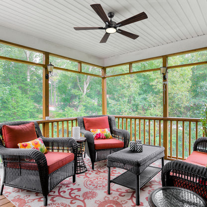 Smafan Apex 56-inch outdoor smart ceiling fan with LED light installed in a screened-in patio with wicker seating and red cushions, surrounded by trees. 