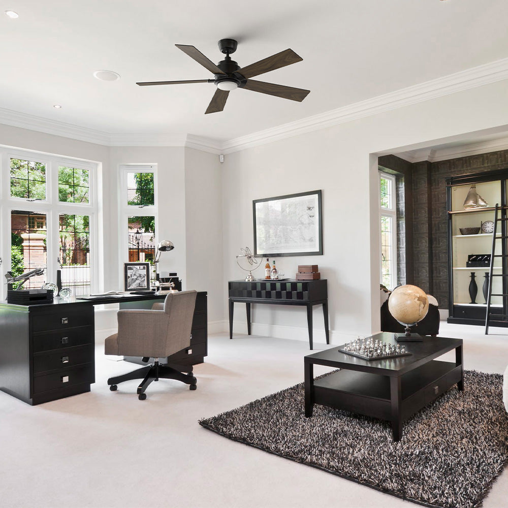 Aspen 52 inch energy efficient ceiling fan with LED light installed in a modern home office. The wood tone 5 blade ceiling fan is mounted on a downrod, complementing the bright contemporary workspace with large windows, black furniture, and neutral décor while providing quiet, high cfm airflow for everyday comfort.  